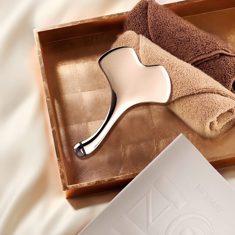 NICEMAY 2338 microcurrent gua sha facial massager displayed with a towel and box.