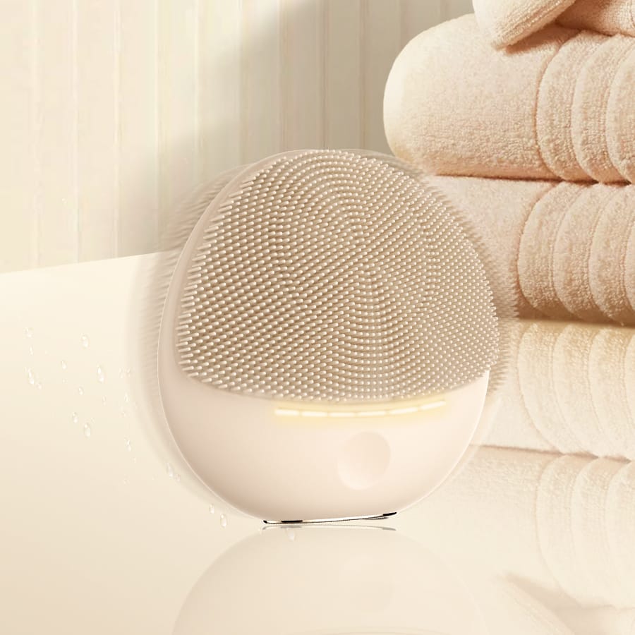 Close-up of the NICEMAY 2369 silicone facial cleansing device with a soft glow.