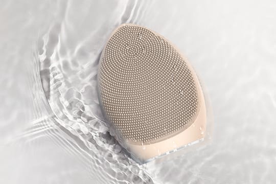 NICEMAY MR-1969 silicone facial brush shown beside rippling water.
